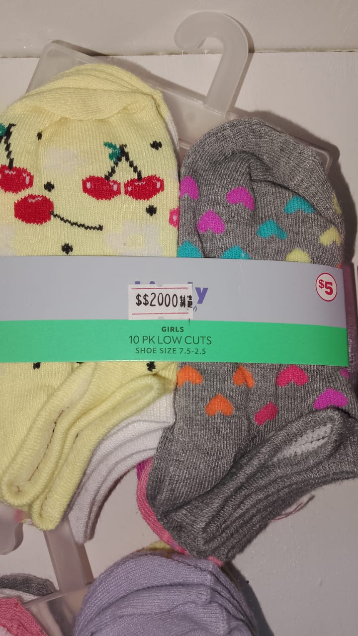 Two pairs of socks with a cherry design and colorful hearts on a hanger with a label.